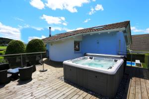 un bain à remous sur la terrasse d'une maison dans l'établissement Villa with Pool - Leon's Holiday Homes, à Dottikon