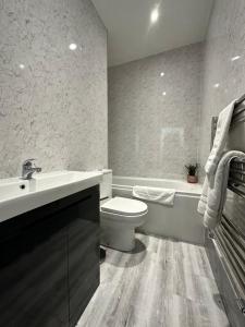 La salle de bains est pourvue d'un lavabo, de toilettes et d'une baignoire. dans l'établissement Belsay 4 bedroom bungalow with loft conversion, à Horden