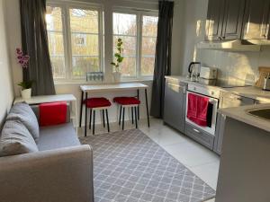 cocina con sofá y mesa con sillas rojas en The Studio en Estocolmo
