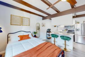 A Place on Palm - Unit 5 في فينكس: غرفة نوم بسرير برتقالي ومطبخ