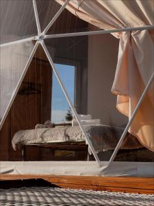 Blick auf ein Schlafzimmer mit einem Bett und einem Spiegel in der Unterkunft Глемпінг Де Вайб (devibe-vorokhta) in Worochta