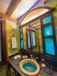 y baño con bañera y vidriera. en Aleli Cottages, en Culebra