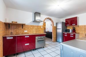 a kitchen with red cabinets and a refrigerator at Gite de la voie verte gitesdes2vallees in Cornimont