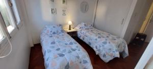 Habitación pequeña con 2 camas individuales y mesa. en Apartamento centrico amueblado en Mendoza