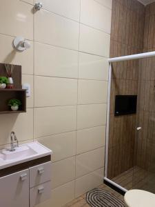 un baño con ducha y lavabo en Meu Refúgio ARRAIAL DO CABO, en Arraial do Cabo