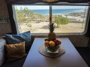 eine Schale mit Obst auf einem Tisch vor einem Fenster in der Unterkunft Alaia Surf Lodge in San José del Cabo
