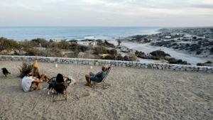 un grupo de personas sentadas en sillas en una playa en Alaia Surf Lodge, en San José del Cabo