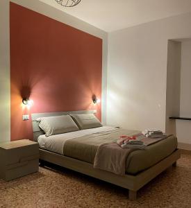 um quarto com uma cama com uma parede vermelha em Dimora T'ama em San Lorenzello
