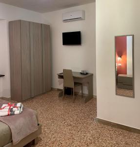 een kamer met een bureau en een tafel met een spiegel bij Dimora T'ama in San Lorenzello