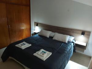 1 dormitorio con 1 cama con 2 toallas en Aire Serrano en Alta Gracia