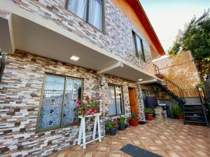 een stenen huis met een patio met potplanten bij Hostal Familiar S&G in Santiago