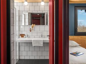 La salle de bains est pourvue d'un lavabo et d'un miroir. dans l'établissement Eklo Lyon, à Vénissieux