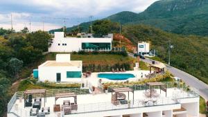 a house on a hill with a swimming pool at Apartamento Mirante de Escarpas 1703 in Capitólio