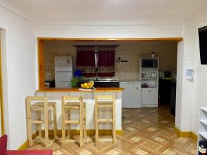 a kitchen with a table, chairs and a refrigerator at Hostal Familiar S&G in Santiago