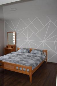 een slaapkamer met een bed en een muur met een spiegel bij Apartmani Šarac - Pale in Pale