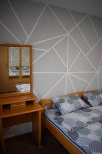 een slaapkamer met een bed, een ladekast en een spiegel bij Apartmani Šarac - Pale in Pale