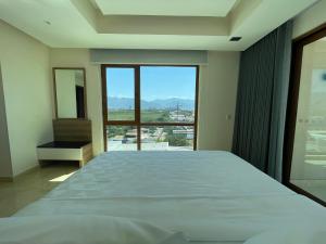 um quarto com uma cama grande e uma janela grande em Holiday Inn & Suites - Puerto Vallarta Marina & Golf, an IHG Hotel em Puerto Vallarta