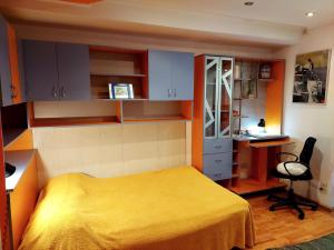 sypialnia z żółtym łóżkiem i biurkiem w obiekcie Studio French Embassy w Bukareszcie