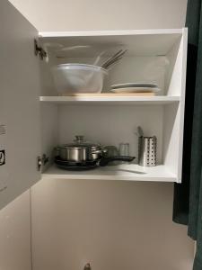 a white cabinet with some dishes and pans in it at Hostel-Centrum in Hamburg