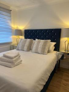 een slaapkamer met een groot bed met witte lakens en kussens bij Beautiful 4 bedroom home 3 bathrooms, Excellent location, Family, Group, Corporate, Contractor in Thamesmead