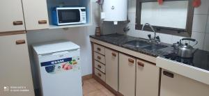 a small kitchen with a sink and a microwave at Coiron in Puerto Madryn