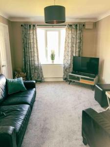 a living room with a couch and a flat screen tv at Mews house 5 minutes walk from the sea in Cleethorpes