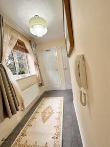 a hallway with a refrigerator and a window and a rug at JOSIS Homes in Wolverhampton