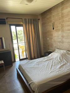 a bedroom with a large bed and a balcony at Santy in Larnaca