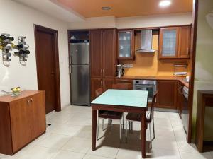a kitchen with wooden cabinets and a table with chairs at Santy in Larnaca