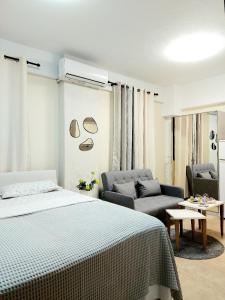 a bedroom with a bed and a couch at PEARL STUDIO free private parking in Thessaloniki