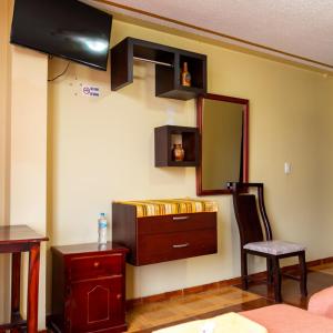 Habitación con tocador y espejo en la pared. en Mashy´s Hostal, en Otavalo