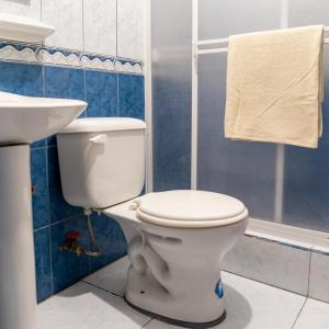 a bathroom with a white toilet and a sink at Mashy´s Hostal in Otavalo