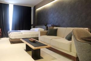 a living room with a couch and a bed at Superior Woodside Residences & Spa Kopaonik in Kopaonik