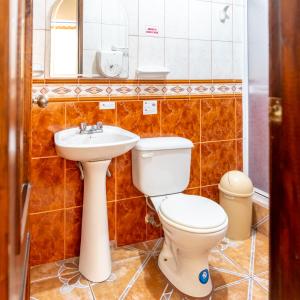 a bathroom with a toilet and a sink at Mashy´s Hostal in Otavalo