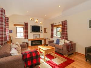 a living room with two couches and a fireplace at Burnt Oak Stables in Mold