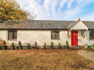 Casa blanca con puerta roja en Burnt Oak Stables en Mold