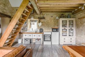 eine große Küche mit einer Treppe in einem Zimmer in der Unterkunft Gîte La Boulangerie de La Trigalle avec SPA privé in Valognes