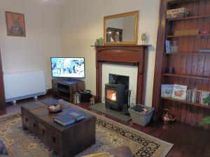 a living room with a fireplace and a television at The Granary in The Square in Grantown on Spey