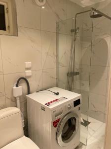 uma casa de banho com uma máquina de lavar roupa e um chuveiro em The Studio em Estocolmo