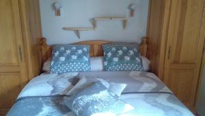 1 dormitorio con 1 cama con almohadas azules en Au bon Accueil anciennement Le Jardin fleuri en Bonnac
