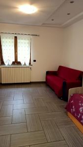 a living room with a red couch and a wooden floor at da Sara in Meana di Susa +21 photos