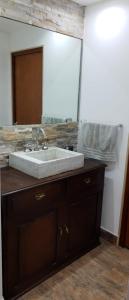 a bathroom with a sink and a large mirror at Casa vacaciones Camet Norte in Camet Norte
