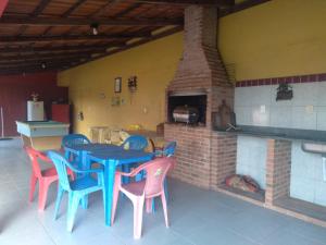 a blue table and chairs in front of a brick oven at Pousada Bromélias - Suítes e Aptos in Nova Viçosa