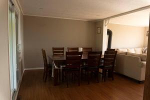 a dining room with a table and chairs and a couch at Cozy Sunset Cottage Overlooking Rice Lake in Roseneath