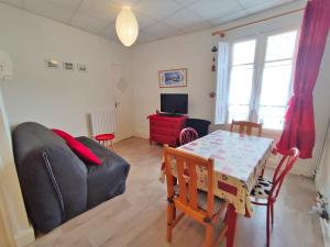 a living room with a table and a couch at Les 3 renards, T2 bis, parking, centre Luchon, casier à skis, 4 personnes in Luchon