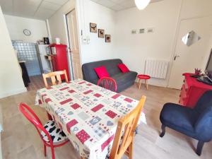 a living room with a table and chairs and a kitchen at Les 3 renards, T2 bis, parking, centre Luchon, casier à skis, 4 personnes in Luchon