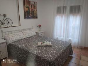 a bedroom with a bed with a black and white bedspread at La Casa de los Patos in Toledo