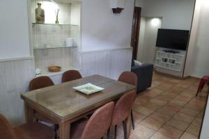 a dining room with a table and chairs and a television at La Casa de los Patos in Toledo