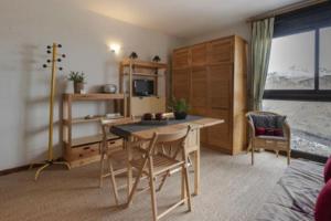 a living room with a dining room table and a kitchen at LA CANELA - Saint Lary Soulan -Pla d'Adet Ski in Saint-Lary-Soulan