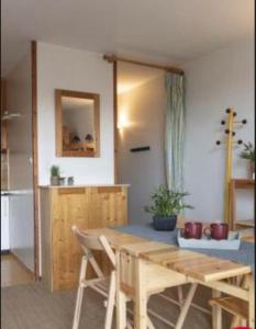 a dining room with a table and a kitchen at LA CANELA - Saint Lary Soulan -Pla d'Adet Ski in Saint-Lary-Soulan